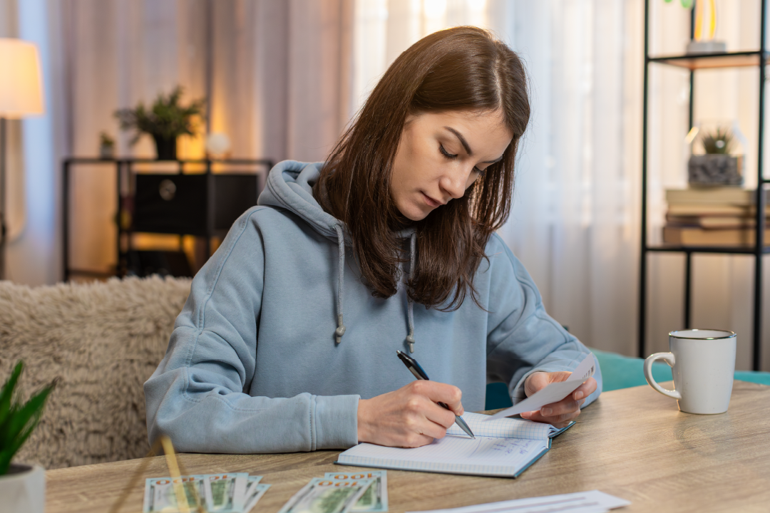 young adult female sitting and going over her monthly budget