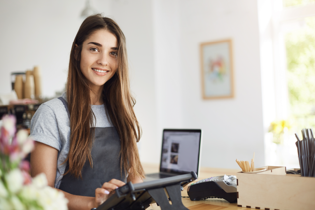 female college student smiling as she's working at her summer job