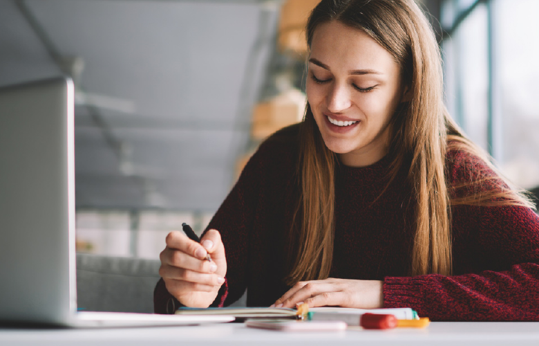 female college student working on classwork and smiling