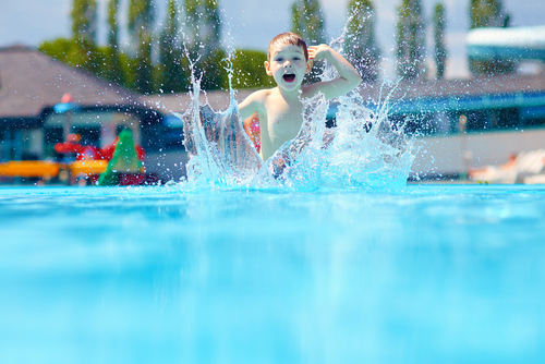 Little boy playing in a pool