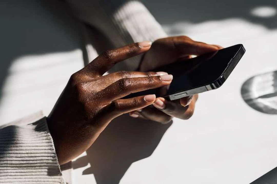 closeup photo of a pair of hands using a smartphone